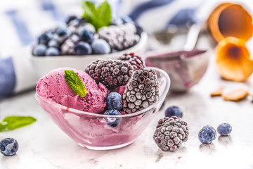 Blueberry and blackberry ice cream in bowl with frozen fruits