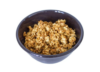 delicious tasty granola with oats flakes fried in honey in the little brown bowl isolated on white background