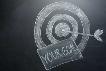 your goal is an inscription with a target on the board. The concept of winning in business and achieving the goal