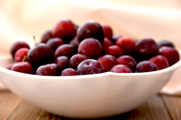 bowl with ripe red plums