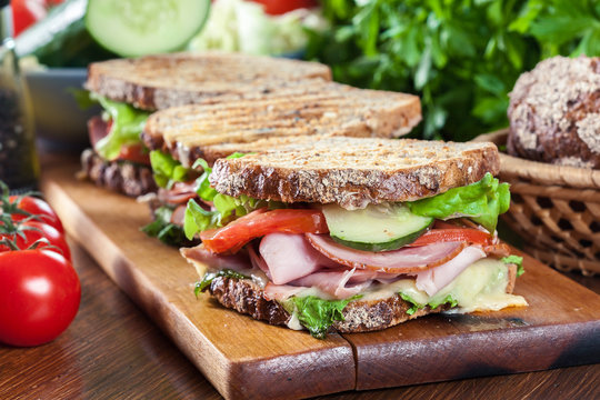 Sandwiches with ham, cheese, tomatoes, lettuce and cucumber