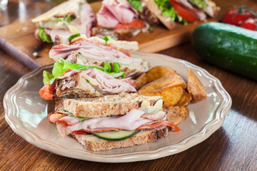 Sandwiches with ham, cheese, tomatoes, lettuce and cucumber