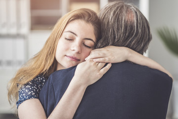 Young daughter hugs her father