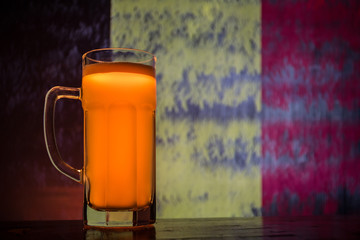 Soccer 2018. Single beer glass on table at dark toned foggy background. Support Belgium with beer concept.