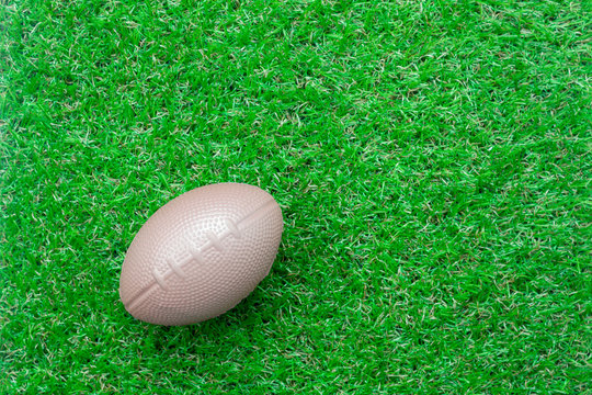 Table top view aerial image accessory football season background.Flat lay object american ball on the artificial green grass wallpaper.Free space for creative design text and content.