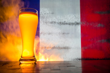 Soccer 2018. Single beer glass on table at dark toned foggy background. Support France with beer...