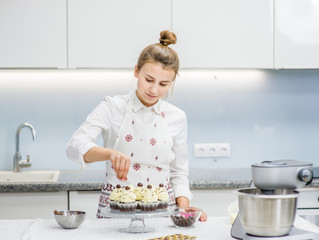 Chef decorates cupcakes on kitchen