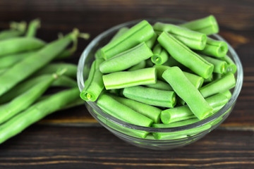 Green beans in the bowl on wooden table