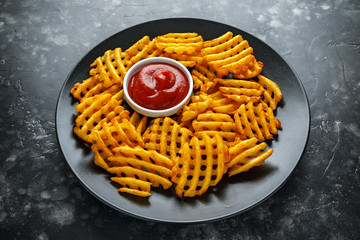 Crispy Potato Waffles Fries with Ketchup in a black plate