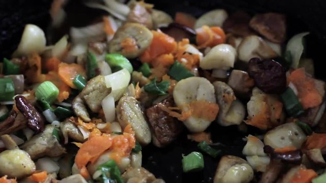 cooking mushrooms and vegetables in a frying pan