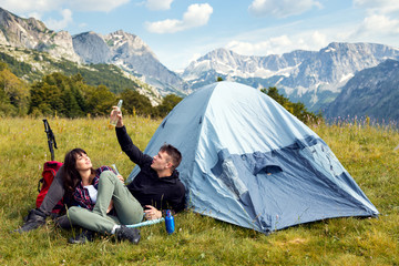 Fototapeta premium Amazing couple camping at mountain and drinking beer