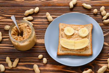 Peanut butter toast with banana slices  on wooden background