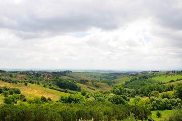 Fototapeta na wymiar Beautiful landscape of hills, cypress trees and houses in Tuscany, Italy