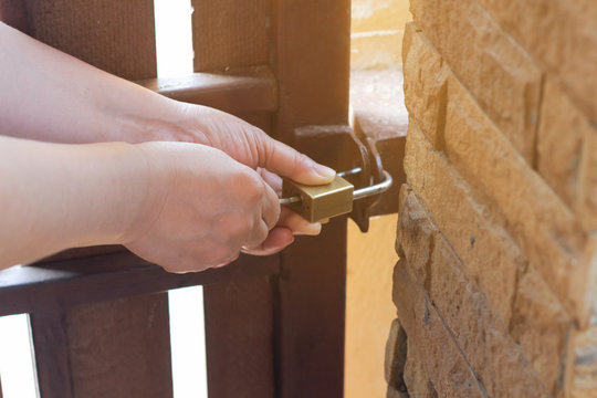The female turns the key in the lock on the outside door open,putting key into front door