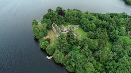 Aerial image of the ruins of Inchmahome Priory on a tree covered island on the picturesque Lake of Menteith.
