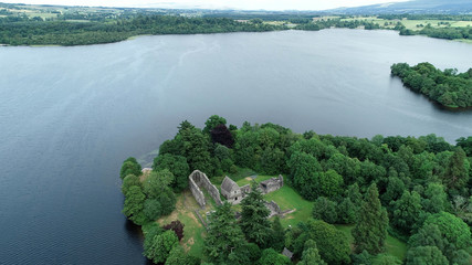 Aerial image of the ruins of Inchmahome Priory on a tree covered island on the picturesque Lake of Menteith.