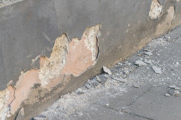 Eine beschädigte Hausmauer und abgeplatzter Außenputz mit einem großen Loch