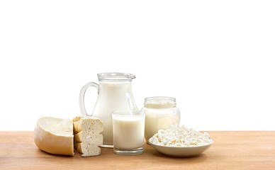 Milk, sour cream, cheese and cottage cheese on wooden table on a white background with space for text