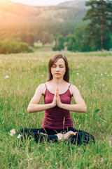 Lifestyle portrait of a beautiful young woman in a yoga position