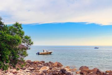 Fototapeta na wymiar Adriatic sea coastline near Budva city in Montenegro, gorgeous seascape with boats in the water and stone beach