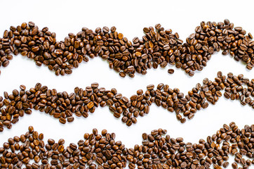 Roasted coffee beans pile on white background a view from the top.