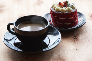 A cup of coffeee and strawberry cake