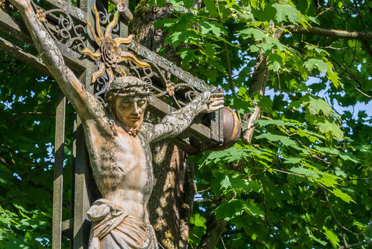 Verwittertes Kreuz aus Eisen mit Jesus Statue