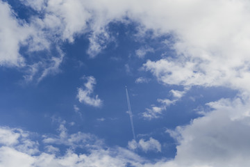 Fototapeta na wymiar A plane through the sky with beautiful clouds.