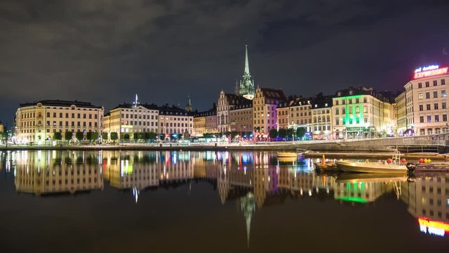 Stockholm Gamla stan buildings 4K Time Lapse Tilt. Old Town cityscape skyline at night, beautiful calm water reflections. Capital city of Sweden