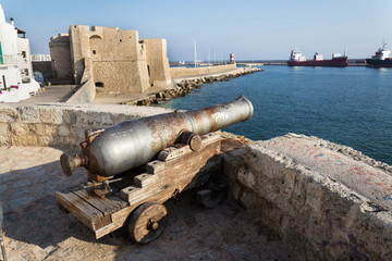 Fototapeta na wymiar Artillery cannon gun in front of Carlo V Castle in port Monopoli, Apulia, Bari province, Italy