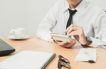 Asian man in white shirt holding pen writing a tax report lead to liquidation and using calculator...