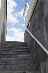 Granite staircase with walls and railings against the sky