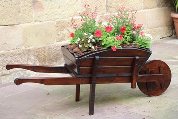 Fototapeta na wymiar lovely wheelbarrow with flowers very creative and original