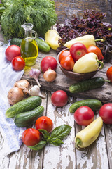 Ripe summer vegetables - tomatoes, lettuce, cucumbers, dill, yellow pepper, olive oil. Vegetables for cooking natural healthy, vegetarian food.