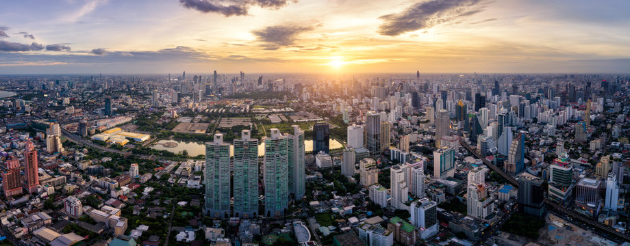 Aerial view of Bangkok skyline and skyscraper on Sukhumvit center of business in capital. Panorama of modern city and BTS skytrain with Benjakiti park on Asoke junction at Bangkok Thailand on sunset
