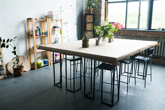 Background Shot Of Creative Art Space Interior Wooden Table With Paintbrushes On It, Loft Styled Workshop,  No People