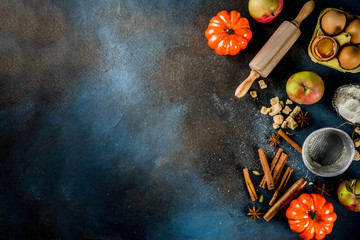 Sweet autumn baking cooking background with flour, rolling pin, decorative pumpkins, apples,...