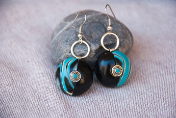 Fototapeta na wymiar Elegance earrings. Black and turquoise earrings with silver rings for woman. Handmade jewelry from polymer clay.
