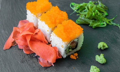 sushi is served on a black stone plate