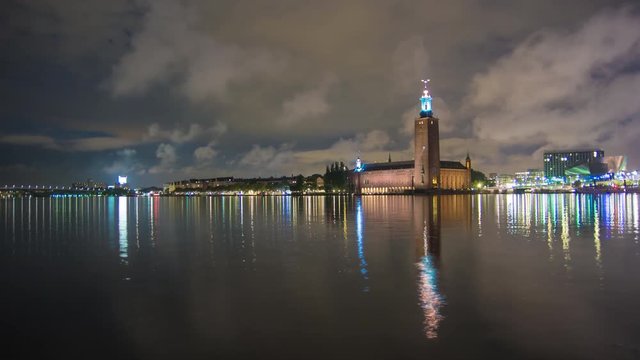 4K Time Lapse Tilt of Stockholm City Hall building at night. Town Hall famous landmark, nobel prize award ceremony. Beautiful water reflections, Capital city of Sweden