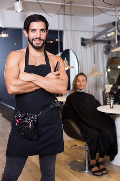 smiling man hairdresser and woman in salon