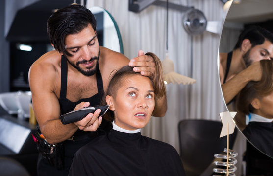 hairdresser with hair clipper with woman