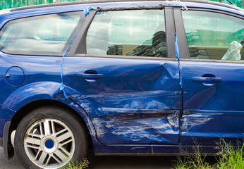 Fototapeta na wymiar Blue car dent in a door in the street after a broken accident