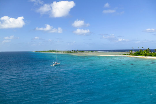 sailing yacht anchoring in the shallow, turquoise lagoon of Fakarava atoll, Tuamotus archipelago, French Polynesia, south pacific