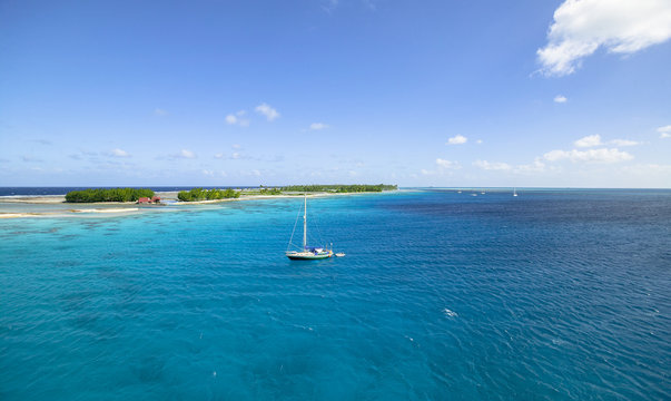 sailing yacht anchoring in the shallow, turquoise lagoon of Fakarava atoll, Tuamotus archipelago, French Polynesia, south pacific