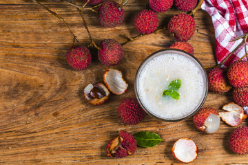 Litchi juice in a glass. Fresh juicy lychee fruit on a glass plate. Organic leechee sweet fruit.