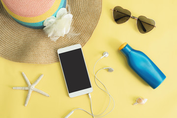 Women's accessories items with smart phone on yellow background, Summer vacation concept
