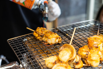 Chef using flame torch burn on Japanese scallop and Japanese shellfish