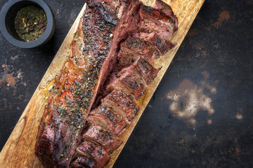 Traditioneller gegrillter Rehrücken aufgeschnitten und mariniert als Draufsicht  auf einem...