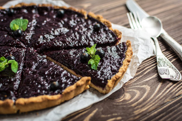 Homemade summer berry tart on a wooden background